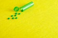 Small green pills with a little green pill bottle Royalty Free Stock Photo