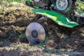 Small green plowing machine in hands of a farmer, tillage equipment, agricultural machine, agriculture, making arable in soil