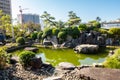 Small green pond next to Fukusai-ji buddhist temple in Nagasaki, with green water and traditional japanese garden trees, Japan.