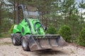 Small green tractor or skid loader parked in forest Royalty Free Stock Photo