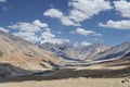 Small green village and river among majestic desert mountains