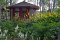 Small green wet garden with wooden gazebos and flooring