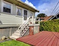Small grey house with staircase to back yard deck. Royalty Free Stock Photo