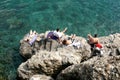 Looking Down on Sunbathers Basking on the Rocks Above the Green Sea