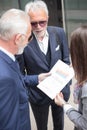 Small group of business people meeting in the street outside of an office building, looking at sales reports Royalty Free Stock Photo