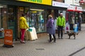 A small group of dog owners meet and chat outside the local pet shop in Hythe in Hampshire on the south coast of England