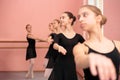 Small group of teenage girls practicing classical ballet in dancing studio