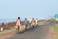 Small group of young and middle aged village people in remote coastal area returning home from work in bicycles. Cycle is the