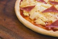 A small Ham and cheese pizza made with par-baked dough, ham, tomato sauce and processed cheese. On a wood tray Royalty Free Stock Photo