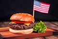 small hamburger with small american flag on it, dark background, US patriotic proud theme, neural network generated