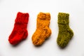 Small, hand knitted woolen socks on light background