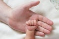 Small hand of a newborn baby on the background of the big palm of his father Royalty Free Stock Photo