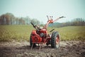 A small hand tractor, walk-behind tractor, plows the land. Work on the field. The concept of agriculture and industry. Royalty Free Stock Photo