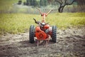 A small hand tractor, walk-behind tractor, plows the land. Work on the field. The concept of agriculture and industry. Royalty Free Stock Photo