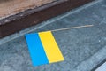Small hand Ukrainian flag placed on the windowsill