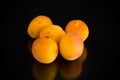 Small handful of ripe apricots on black background