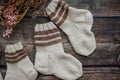 Small handmade baby socks on dark wooden background