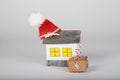 Small handmade paper house and Santa Claus hat on it
