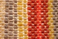 A small handmade rug or mat, woven from red and yellow wool threads, one object close-up Royalty Free Stock Photo