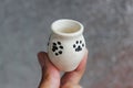 Small handmade white clay with cat paws pot for making wishes or flowers from boutonnieres. Decor engobe, covered with transparent