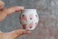 Small handmade white clay pot for making wishes or flowers from boutonnieres. Decor engobe, covered with transparent glaze, two