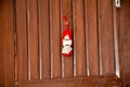 A small hanging red doll in the wooden brown door