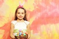 Small happy baby girl holding pottle with easter eggs