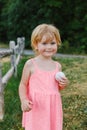 Small happy child playing outdoors in summer. Smiling little girl holding a ball in park on sunny day. Royalty Free Stock Photo