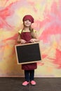 Small happy girl chef in hat, apron with blackboard Royalty Free Stock Photo