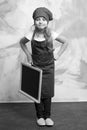 Small happy girl chef in hat, apron with blackboard Royalty Free Stock Photo