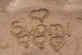 Small hearts and word Suomi handwritten on a sandy beach Royalty Free Stock Photo
