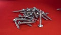 Small hex head screws on a red background Royalty Free Stock Photo