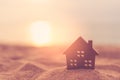 Small home model on sunset beach sand texture background Royalty Free Stock Photo