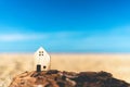 Small home model on sunset beach sand texture background Royalty Free Stock Photo