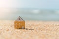 Small home model on sunset beach sand texture background Royalty Free Stock Photo