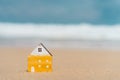 Small home model on sunset beach sand texture background Royalty Free Stock Photo