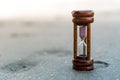 Small hourglass show time is flowing on sand beach background Royalty Free Stock Photo