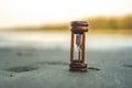 Small hourglass show time is flowing on sand at beautiful beach Royalty Free Stock Photo