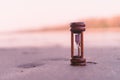 Small hourglass show time is flowing on sand at beautiful beach Royalty Free Stock Photo