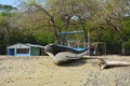 Small house, boat and trees on sandy beach Royalty Free Stock Photo