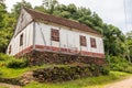 Small house in enxaimel style, dirty road with flowers and plants around