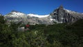 Small house in forest next to dramatic gray rock snow mountains, Stunning view of San Martin Hut or Refugio Jakob in Nahuel Huapi Royalty Free Stock Photo
