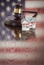 Small House and Gavel on Table with American Flag Reflection Royalty Free Stock Photo