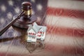 Small House and Gavel on Table with American Flag Reflection Royalty Free Stock Photo