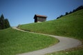 a small house on a hillside near a road