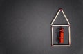 Small house made of matches with a miniature fire extinguisher inside. Business fire insurance concept