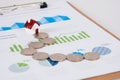 The small house model on the financial chart and the abstract path made of dollars and coins Royalty Free Stock Photo