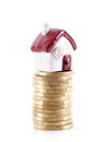 Small house model lifted by a stack of euro coins on white background Royalty Free Stock Photo