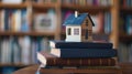 A small house model placed on a stack of books Royalty Free Stock Photo