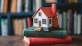 A small house model placed on a stack of books Royalty Free Stock Photo